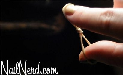 Użyć gumki recepturki do francuskiego manicure.
