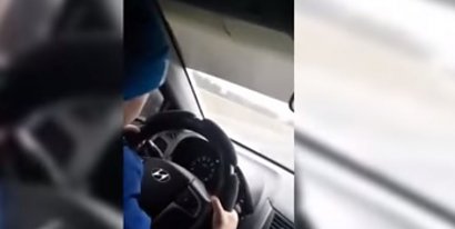 Przedstawia 6-letnie dziecko za kierownicą.