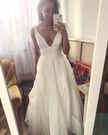 31-latka wybrała dość prostą suknię ślubną z głębokim dekoltem typu V sięgającym aż do pasa.