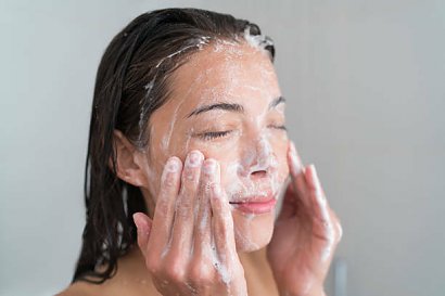 Kobieta myje twarz po peelingu gruboziarnistym
