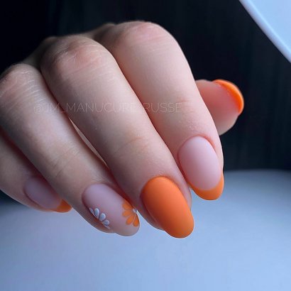 Zobacz piękne stylizacje manicure na kwiecień 2022 - tutaj matowa stylizacja w pomarańczach z białym akcentem - kwiatuszki i french