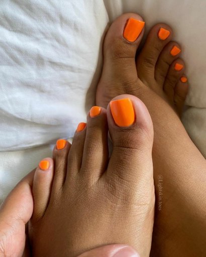 Neonowy pomarańcz u stóp fantastycznie komponuje się z opaloną skórą.