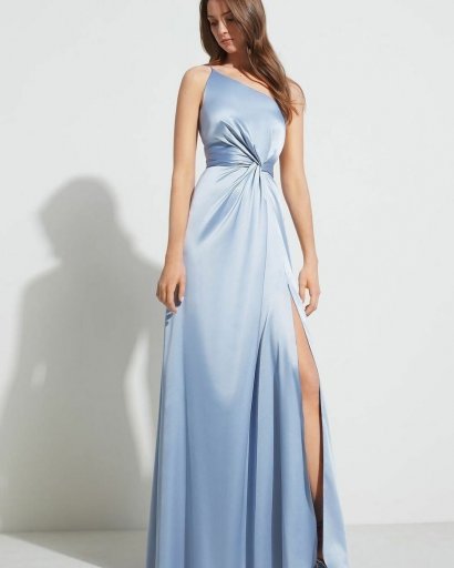 Długa jasnobłękitna sukienka z błyszczącego materiału z efektownym rozporkiem z boku spódnicy.