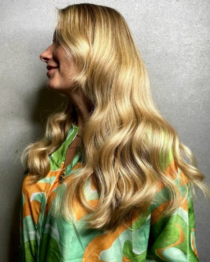 Piękny przykład złotego blondu na długich włosach ze lśniącymi falami.