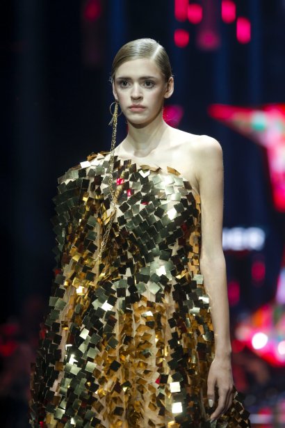 Asymetryczna sukienka zbudowana ze złotych kwadracików.